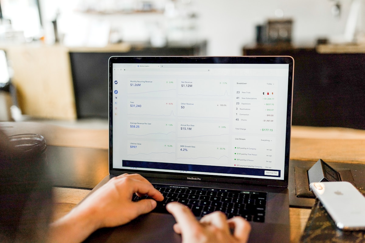 Business owner comparing WhatsApp Business API and standard app interfaces on a laptop screen.